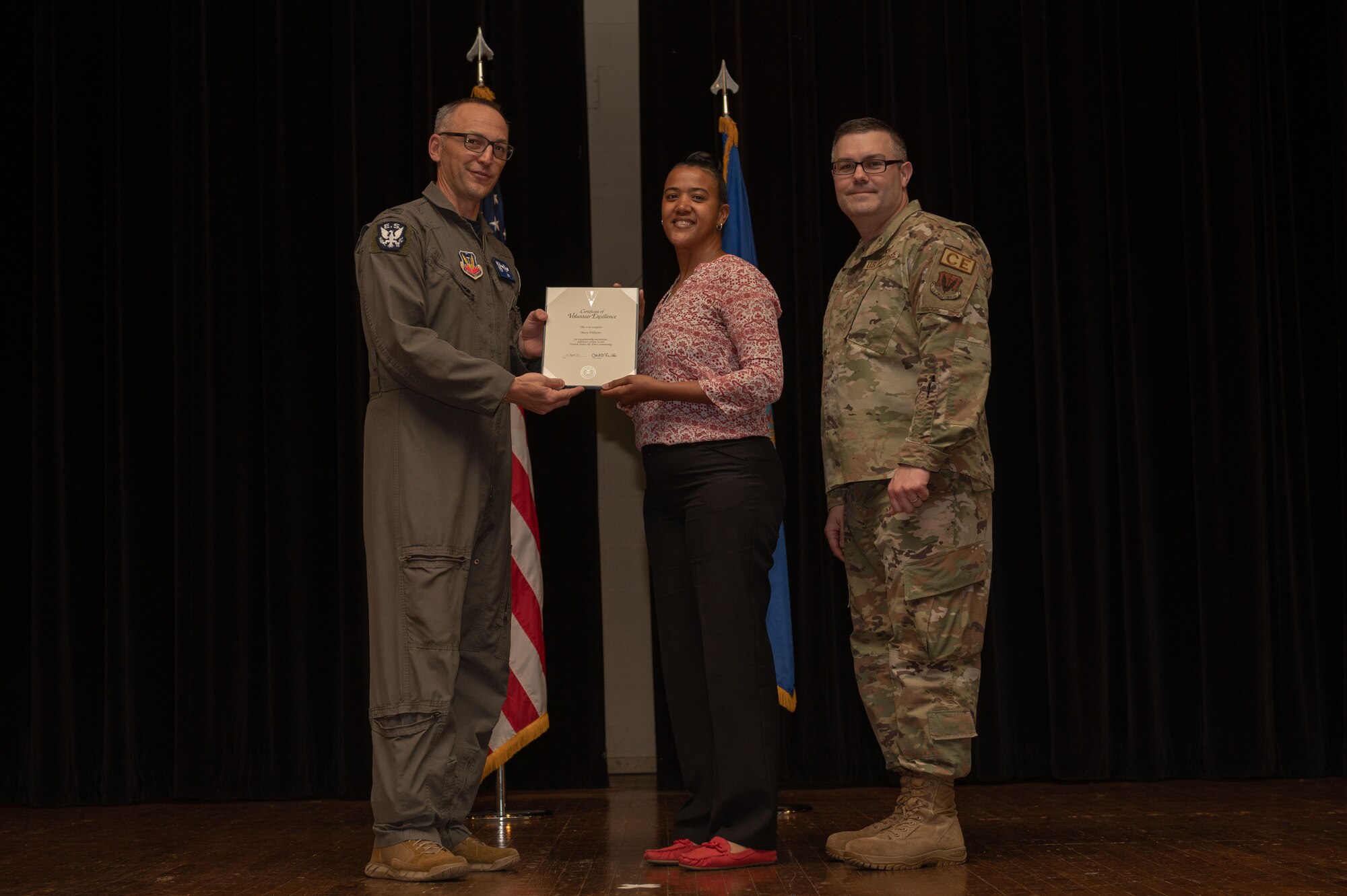 Col. Steven Bofferding, left, 4th Fighter Wing vice commander, and Chief Master Sgt. Kyle O’Hara, right, 4th Civil Engineer Squadron command chief, present the Volunteer Excellence Award to Mary Williams, center, during a volunteer appreciation ceremony at Seymour Johnson Air Force Base, North Carolina, April 21, 2023. This award recognizes sustained, direct and impactful service. (U.S. Air Force photo by Airman 1st Class Rebecca Sirimarco-Lang)