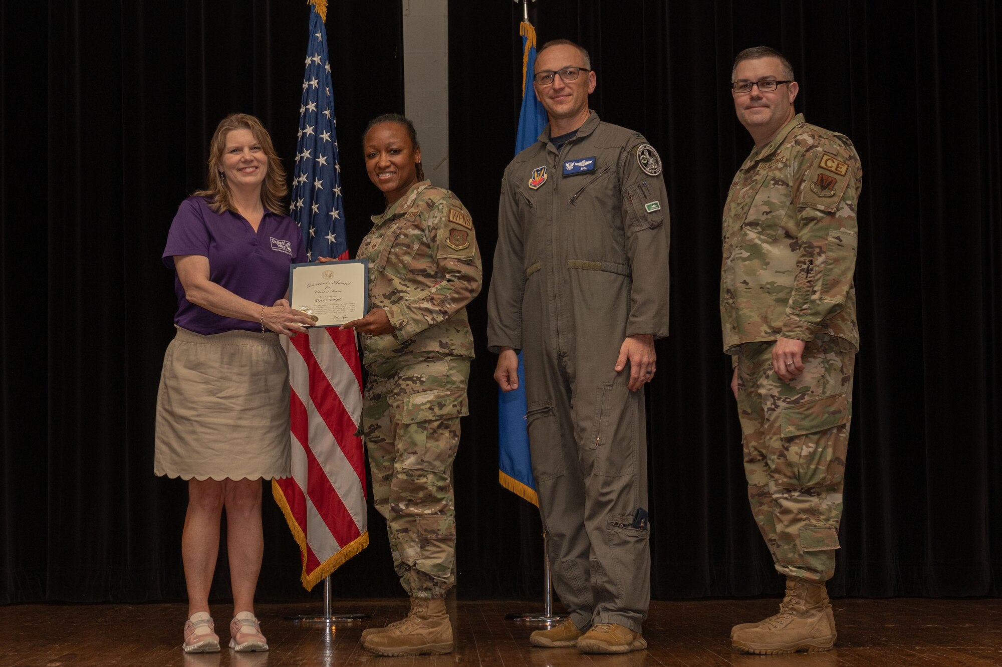 Col. Steven Bofferding, 4th Fighter Wing vice commander, Chief Master Sgt. Kyle O’Hara, right, 4th Civil Engineer Squadron command chief, and Sherry Archibald, left, United Way executive director, present the North Carolina Governor’s Volunteer Service Award to Master Sgt. Tyneka Kearse, 4th Maintenance Group quality inspector, who accepts the award for Senior Airman Tyree Boyd, 4th Maintenance Group weapons system coordinator, during a volunteer appreciation ceremony at Seymour Johnson Air Force Base, North Carolina, April 21, 2023. This award honors the true spirit of volunteerism by recognizing individuals, groups and businesses that make a significant contribution to their community through volunteer service. (U.S. Air Force photo by Airman 1st Class Rebecca Sirimarco-Lang)