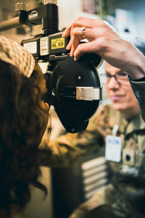 Lieutenant Colonel Virginia Gilmore positions an optical instrument in front of a Sailor aboard the USS Carl M. Levin. The team is from the 101st Air Refueling Wing and traveled to the destroyer located at Bath Iron Works on April 20, 2023 to assist in prepping the crew for the ships maiden voyage.