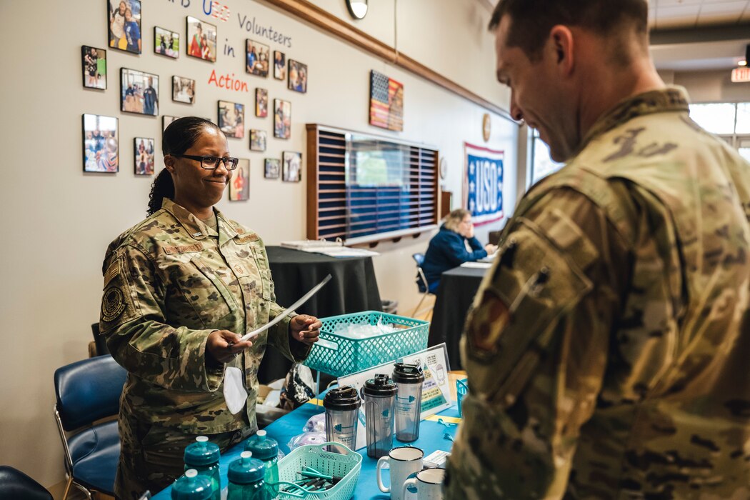 Master Sgt. Tiffany Porterfield, Sexual Assault Prevention and Response volunteer victim advocate, speaks with an Airman at the Sexual Assault Awareness and Prevention Month booth during the USO’s blood drive event April 25 at Wright-Patterson Air Force Base, Ohio.