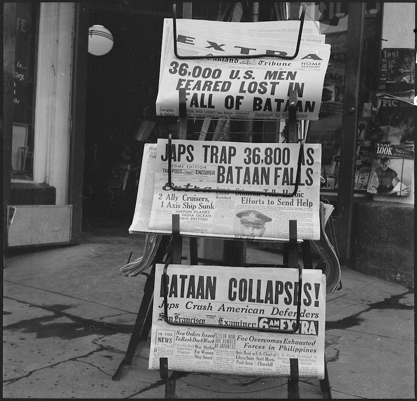 Newspapers on a stand highlight the fall of the Bataan peninsula.