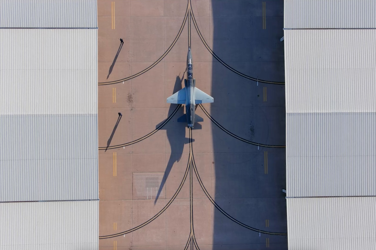 Overhead view of an aircraft taxiing on a flight line.