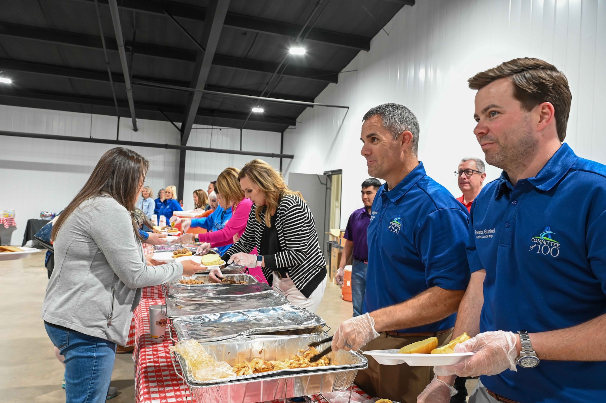 Members of the Altus Chamber of Commerce’s Committee of 100 serve chicken and pulled pork to Airmen and their families at the Jackson County Expo Center in Altus, Oklahoma, April 24,2023. The food was catered by an Oklahoma-based barbecue restaurant. (U.S. Air Force photo by Airman 1st Class Kari Degraffenreed)