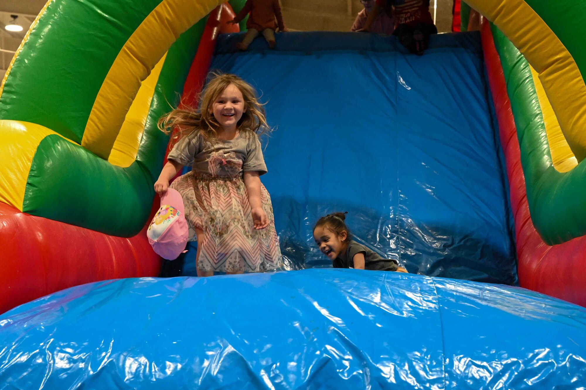 Children slide down the bounce house at a Committee of 100 event in Altus, Oklahoma, April24, 2023. Around 200 Airmen and families came to the Altus Chamber of Commerce’s Committee of 100 military appreciation dinner. (U.S. Air Force photo by Airman 1st Class Kari Degraffenreed)