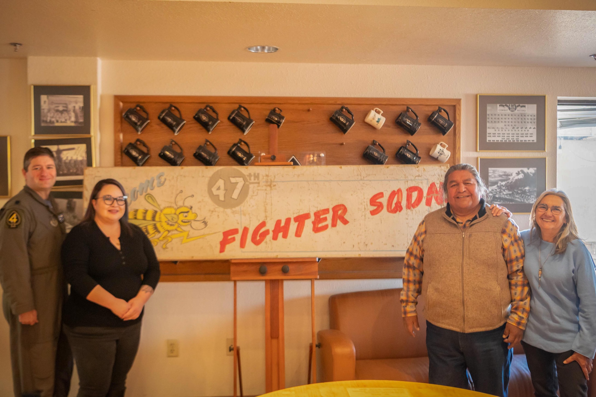 U.S. Air Force Reserve Citizen Airman Lt. Col. Timothy Mitchell, former 47th Fighter Squadron commander, and Jessica Lawson, 944th Fighter Wing historian, take a photo with Art Conservators Timothy Lewis and Matilde Rubio, Tohono Restoration, after they unveiled the units’ flag from WWII at the 47th FS clubhouse at Davis-Monthan Air Force Base, Ariz., March 3, 2023. Lawson worked with the National Museum of the United States Air Force to find a restorer who could protect and preserve this historical flag. (U.S. Air Force photo by Staff Sgt. Tyler J. Bolken)