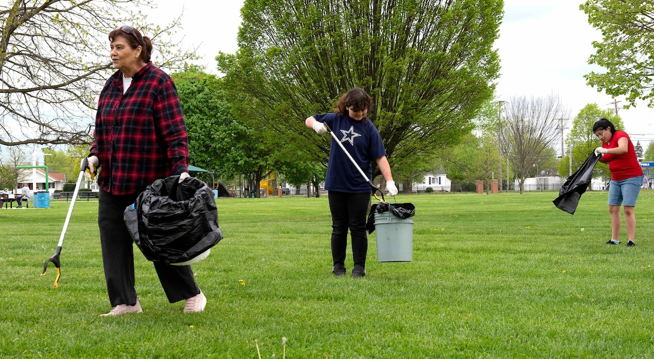 Three family members pick up trash at Fairborn Central park.