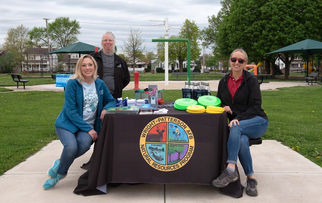 Three females pose for an Earth Day photo.