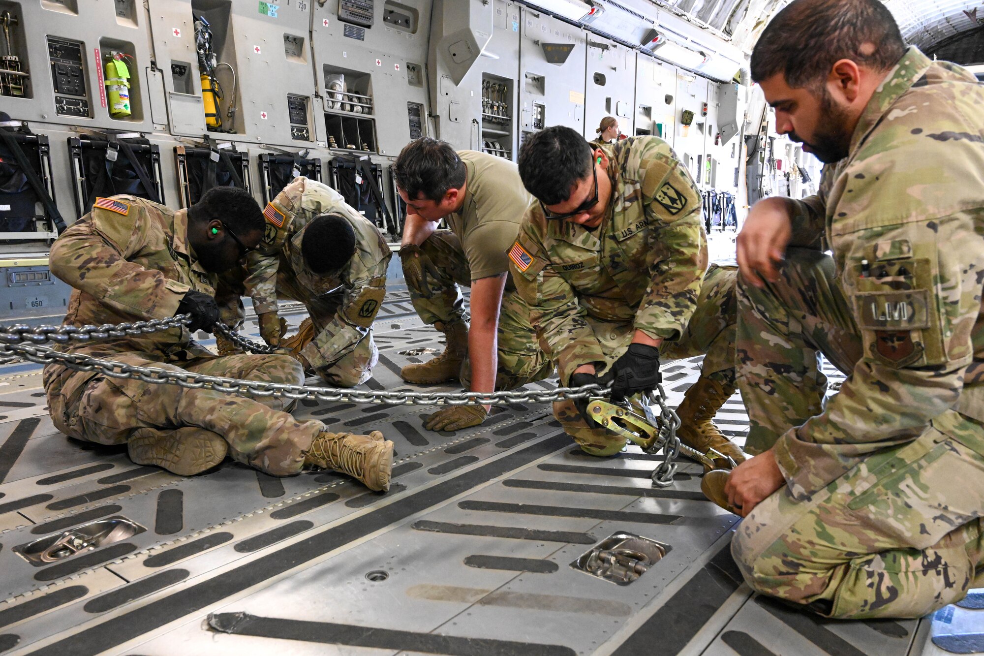 U.S. Soldiers complete vehicle tiedown operations on C-17 Globemaster III under the supervision of U.S. Airmen from the 97th Air Mobility Wing at Altus Air Force Base, Oklahoma, April 19, 2023. In conjunction with the loadmasters, the Soldiers were able to complete loading and tie down operations. (U.S. Air Force photo by Senior Airman Trenton Jancze)