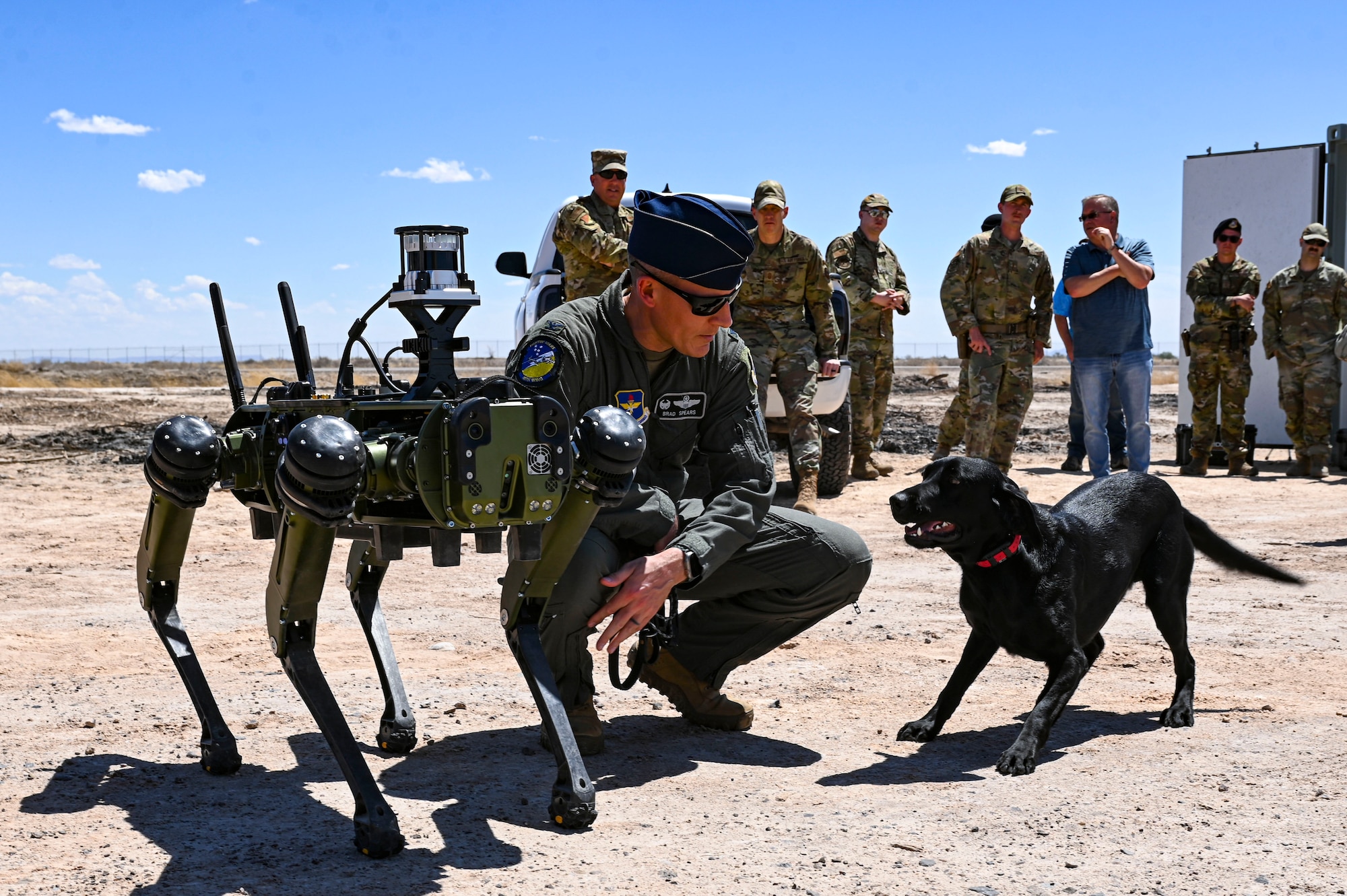 U.S. Air Force Col. Justin Spears, 49th Wing commander, introduces his dog Blue to a Vision 60 Q-UGV ground robot at Holloman Air Force Base, New Mexico, April 17, 2023. The Vision 60 is a quadrupedal ground robot that is capable of maneuvering through rough terrains, making it perfect for patrolling Holloman’s arid environment. (U.S. Air Force photo by Airman 1st Class Isaiah Pedrazzini)