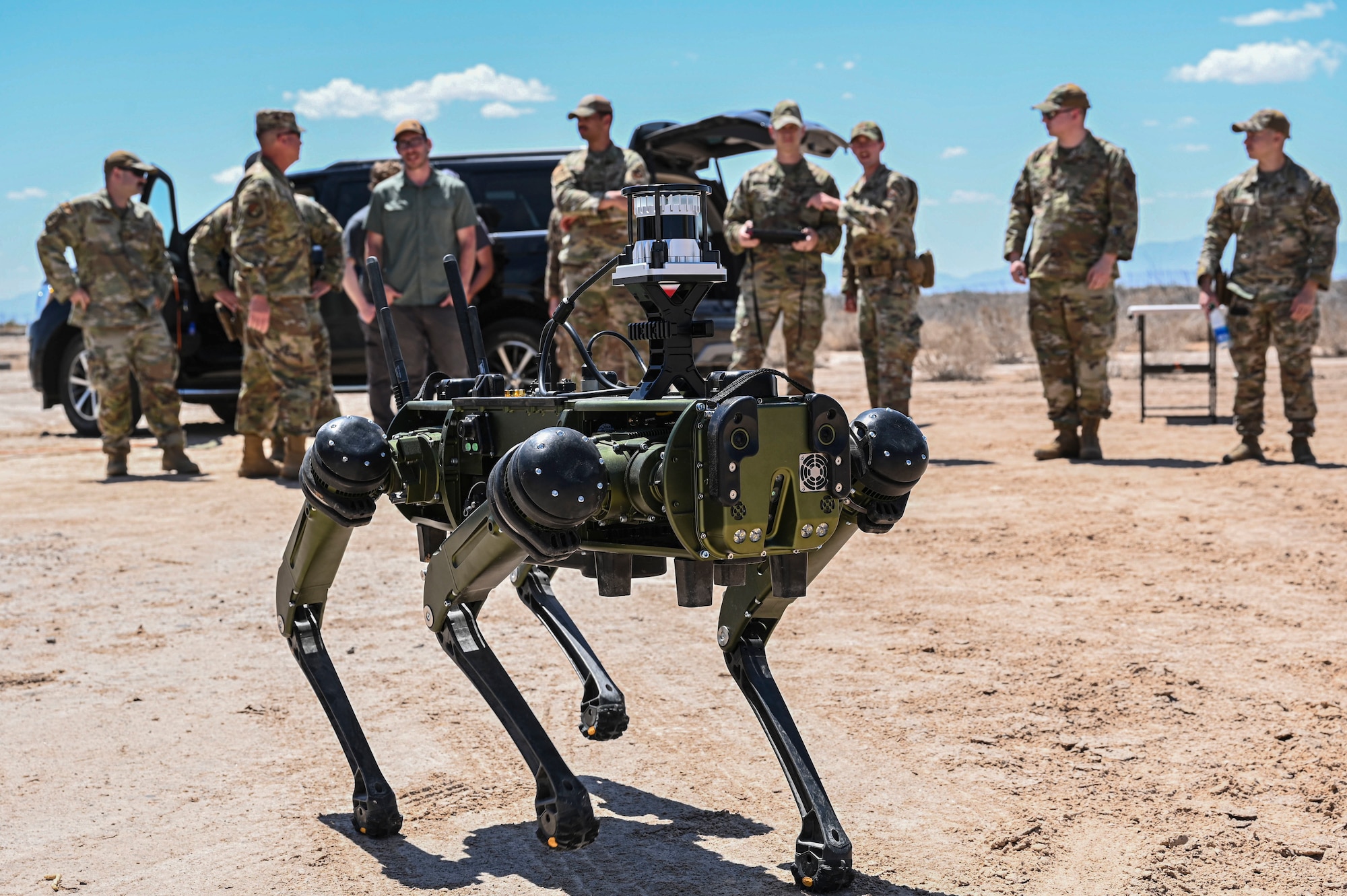 Members and leadership from the 49th Wing and 49th Security Forces Squadron watch a demonstration of a Vision 60 Q-UGV ground robot in action at Holloman Air Force Base, New Mexico, April 17, 2023. The Vision 60 is capable of withstanding various environmental challenges making it the perfect tool for all-weather operations taking place on base. (U.S. Air Force photo by Airman 1st Class Isaiah Pedrazzini)