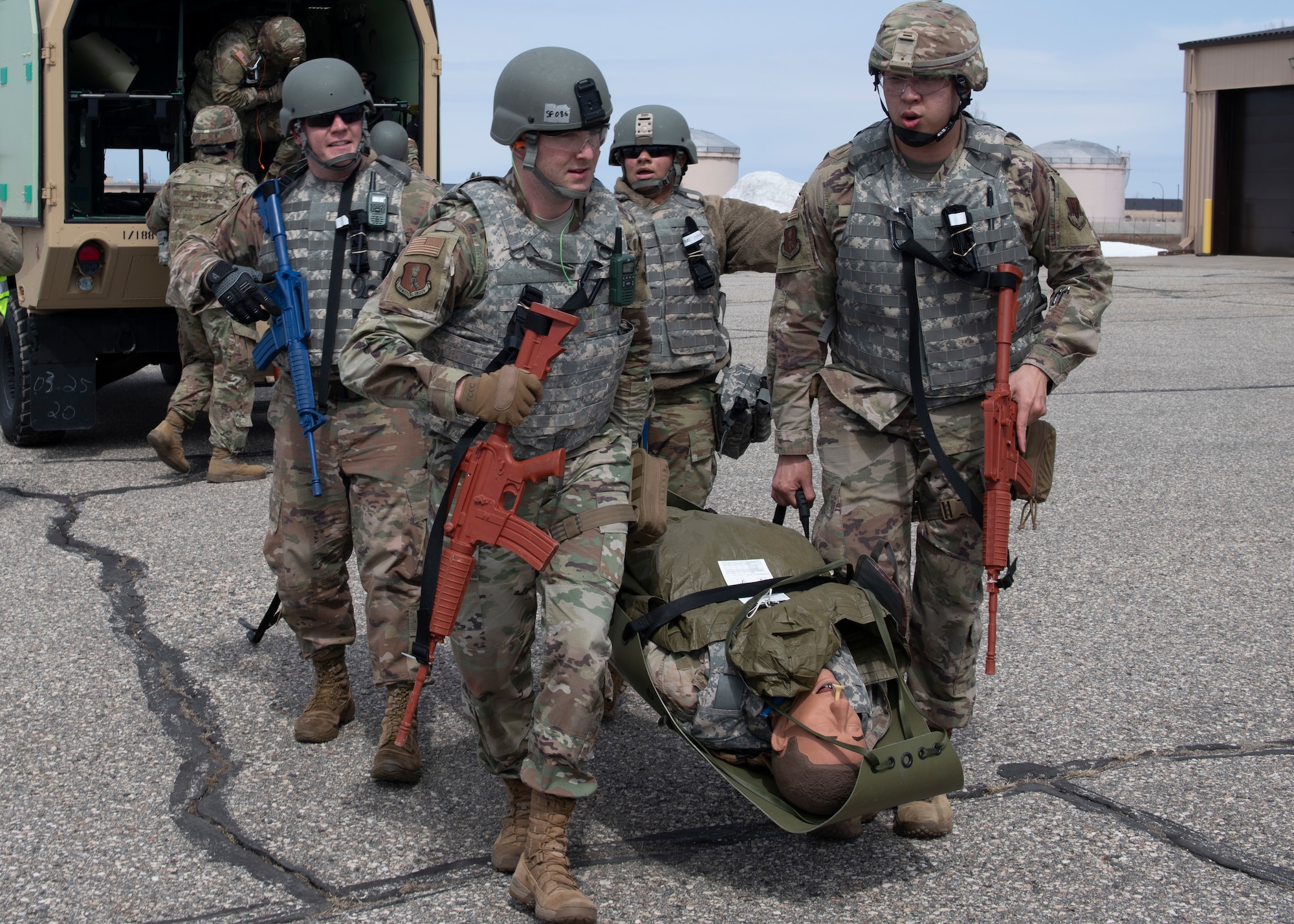 Servicemembers carry a mannequin on a stretcher.