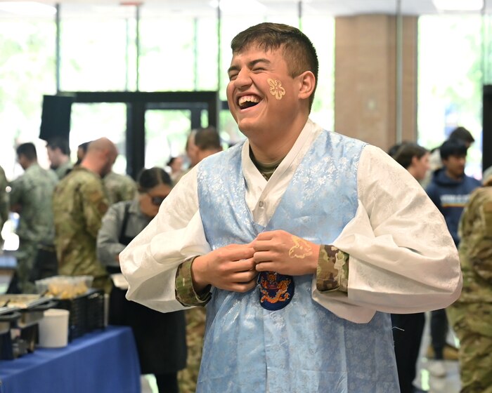 U.S. Army Pfc. Carlos Vizcarrondo, 316th Training Squadron student, wears traditional clothing from the South Korean Language and Culture booth at the Angelo State University and Goodfellow Air Force Base Language and Culture Fair in San Angelo, Texas, April 27, 2023. The fair is designed to allow both GAFB students and ASU students to explore and celebrate linguistic and cultural differences. (U.S. Air Force photo by Airman 1st Class Zach Heimbuch)