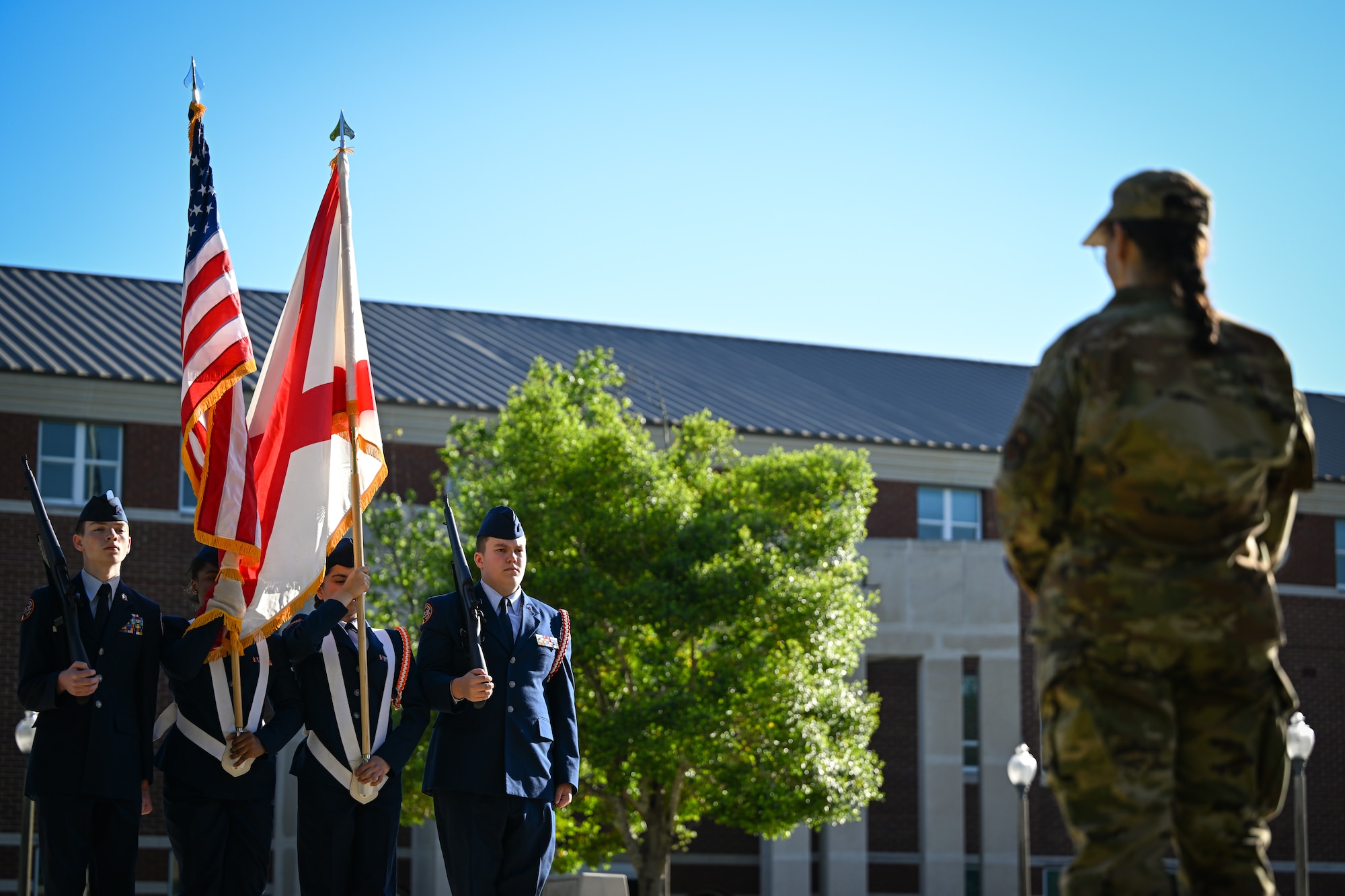 Brig. Gen. Lisa M. Craig observes JROTC cadets performing on a drill pad