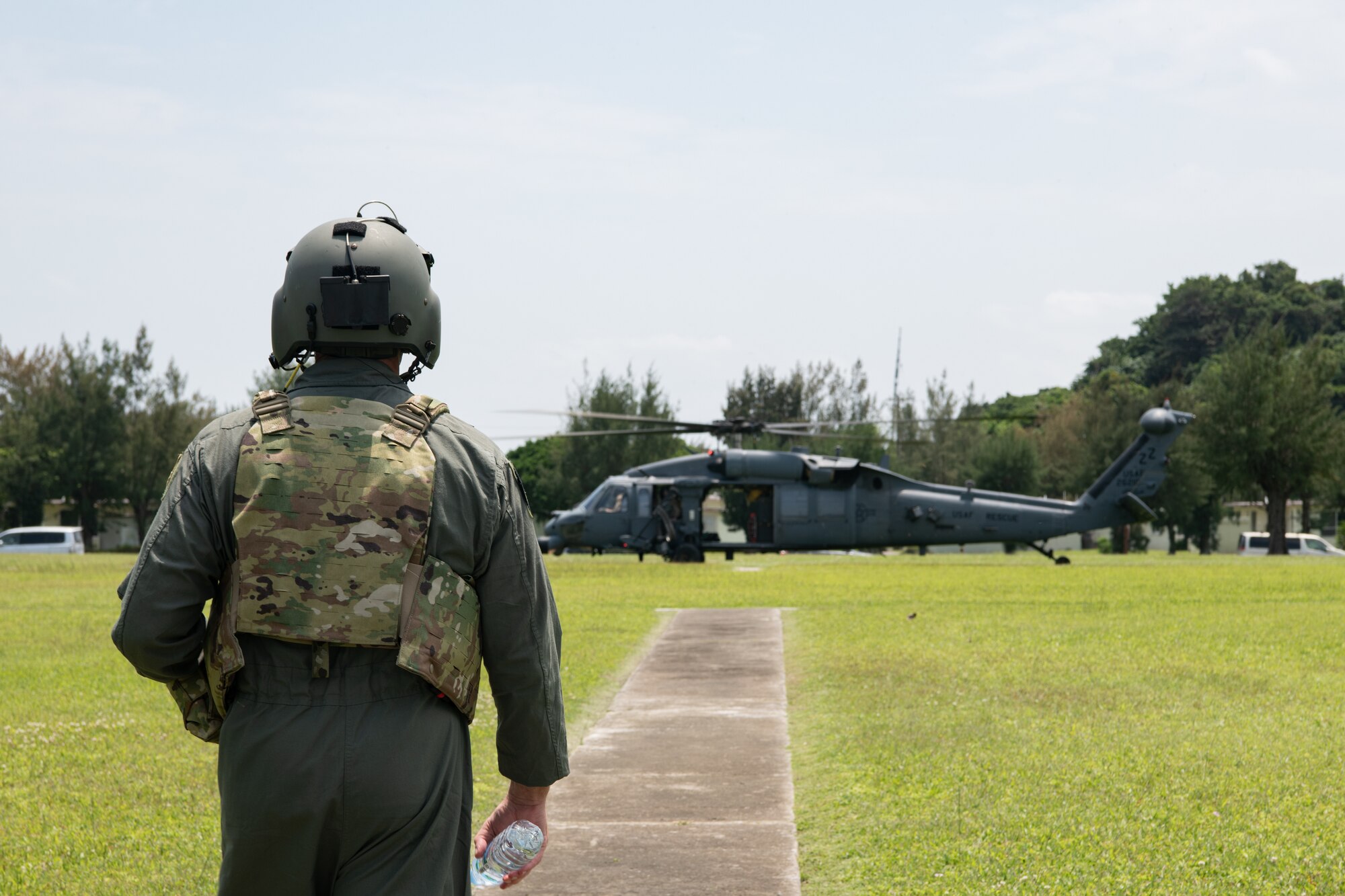 The wing commander watches a helicopter land.