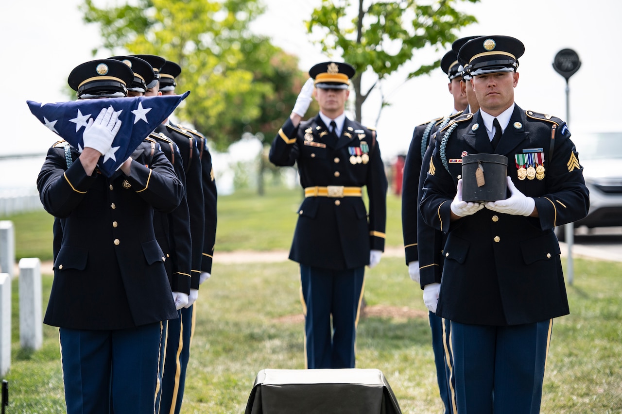 A group of service members stand at attention.