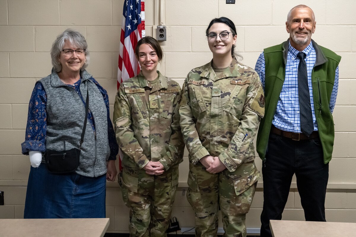 Air Force Senior Airman Janelle Bonitati, center-left, and Staff Sgt. Marlena Hargraves, center-right, from Indiana’s 19th Chemical, Biological, Radiological, Nuclear, and High-yield Explosives Enhanced Response Force Package, with Leslie Legg-Carlson and John Carlson at Hulman Field Air National Guard Base, Ind., April 16, 2023. On Dec. 3, 2022, Hargraves and Bonitati were driving on I-70 after the duty day when they rescued the Carlsons from a vehicle crash.