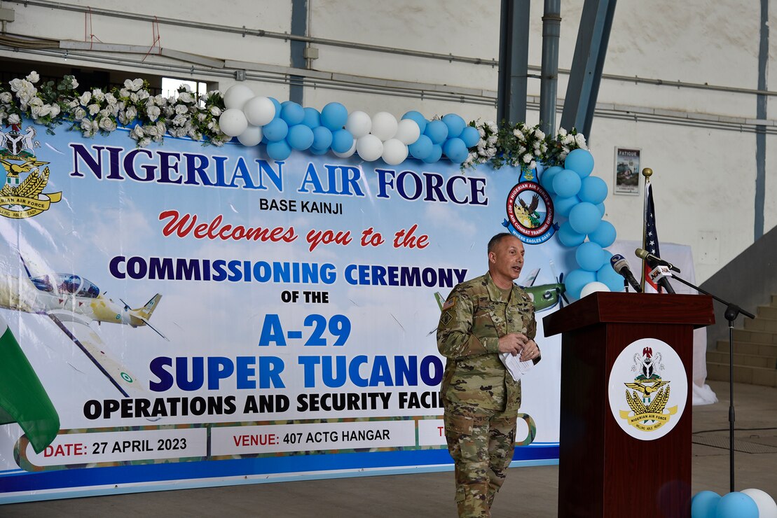 A man in a military uniform speaks at a podium