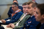 Four men sitting and watching a presentation