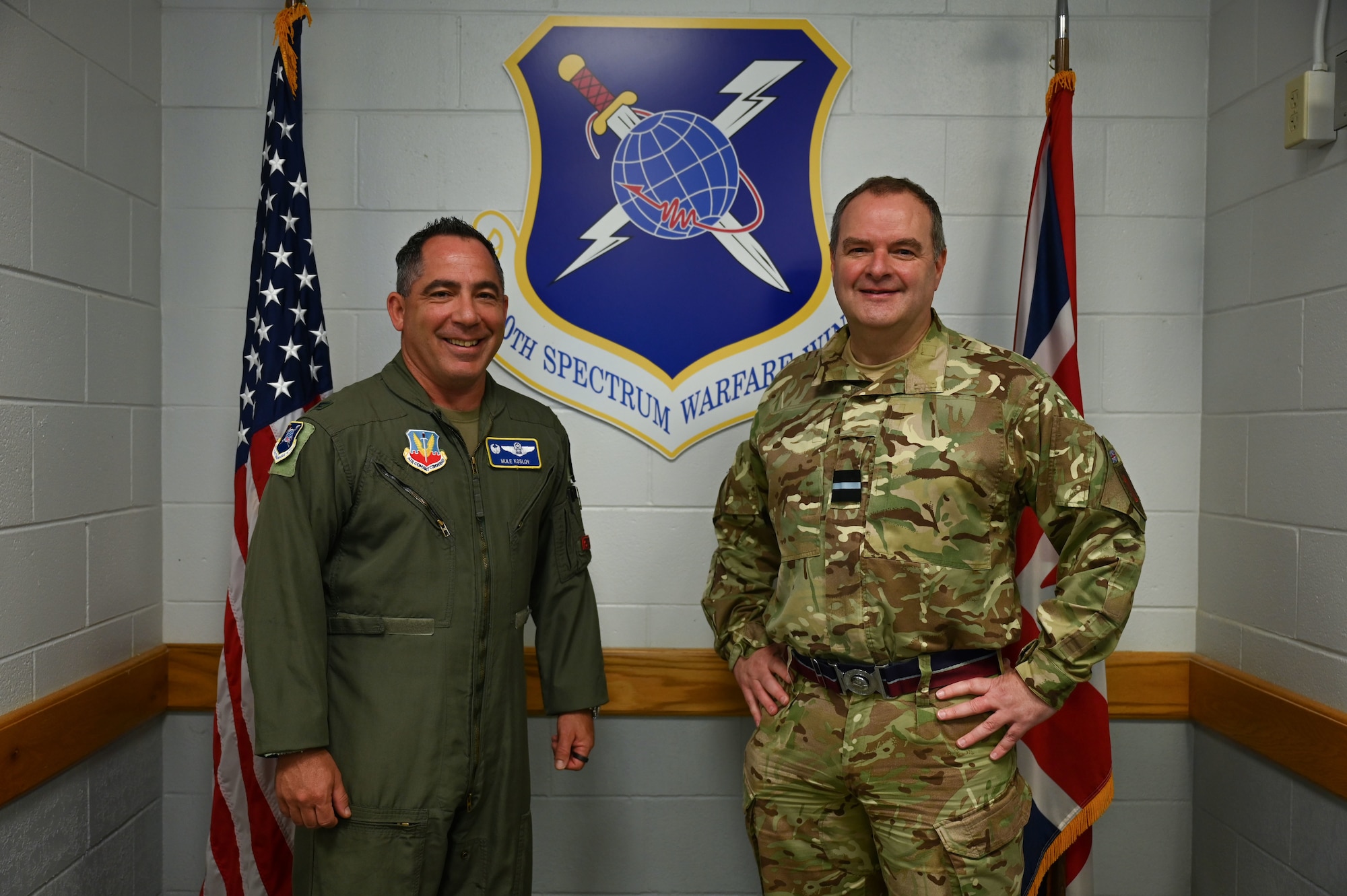 U.S. Air Force Col. Josh Koslov, 350th Spectrum Warfare Wing commander, left, and Royal Air Force Commodore Blythe Crawford, Air and Space Warfare Center commandant, right, pose for a photo at Eglin Air Force Base, Fla., April 26, 2023. Interoperability with allies is paramount to restricting our adversaries have to the EMS. (U.S. Air Force photo by Staff Sgt. Ericka A. Woolever)
