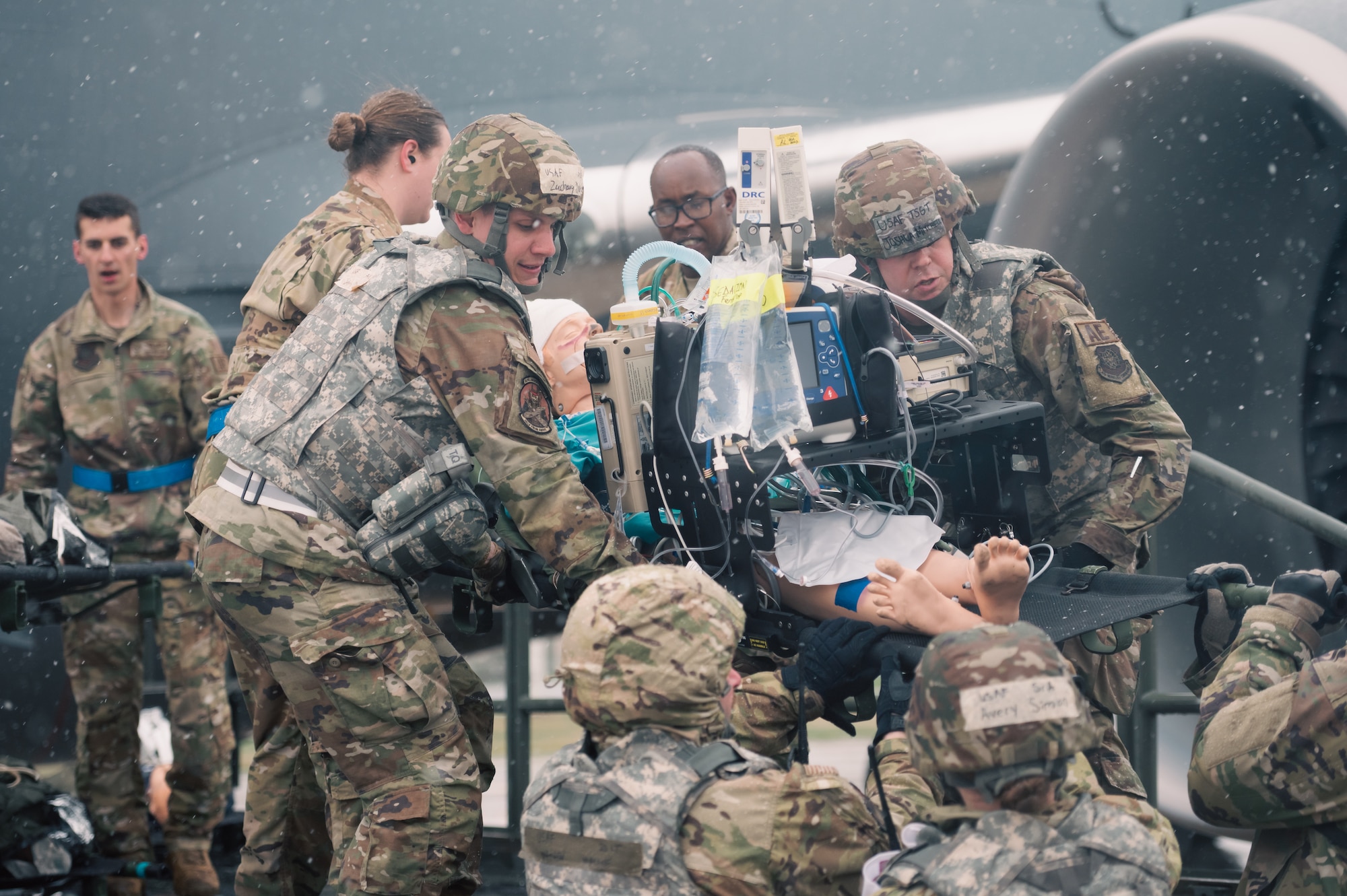 Airmen load simulated patient onto aircraft