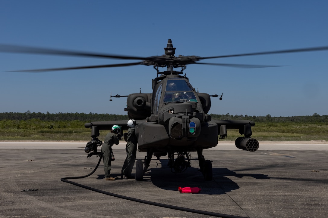 U.S. Marine Corps Cpl. Tara Potter, left, and Gunnery Sgt. David Law, load masters with Marine Aerial Refueler Transport Squadron (VMGR) 252 conduct ground refueling on an Army Boeing AH-64E Apache in support of 10th Mountain Division at Hurlburt Field, FL, April 19, 2023. VMGR- 252 participated in exercise Emerald Warrior 4-23 to increase joint interoperability in a littoral environment. VMGR-252 is a subordinate unit of 2nd Marine Aircraft Wing, the aviation combat element of II Marine Expeditionary Force. (U.S. Marine Corps photo by Lance Cpl. Orlanys Diaz Figueroa)