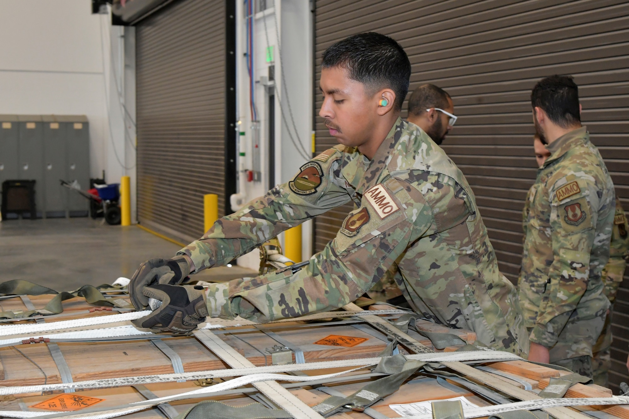 An Airman secures cargo netting on a pallet load