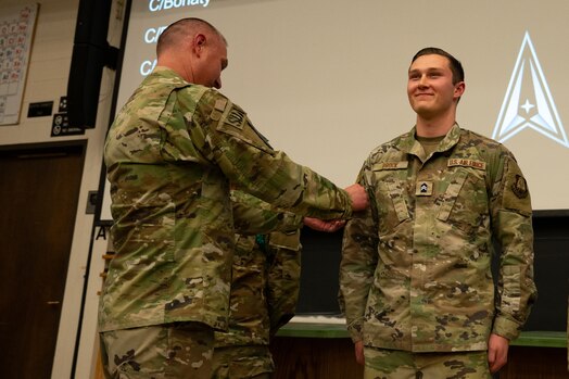  Man places patch on his son's uniform