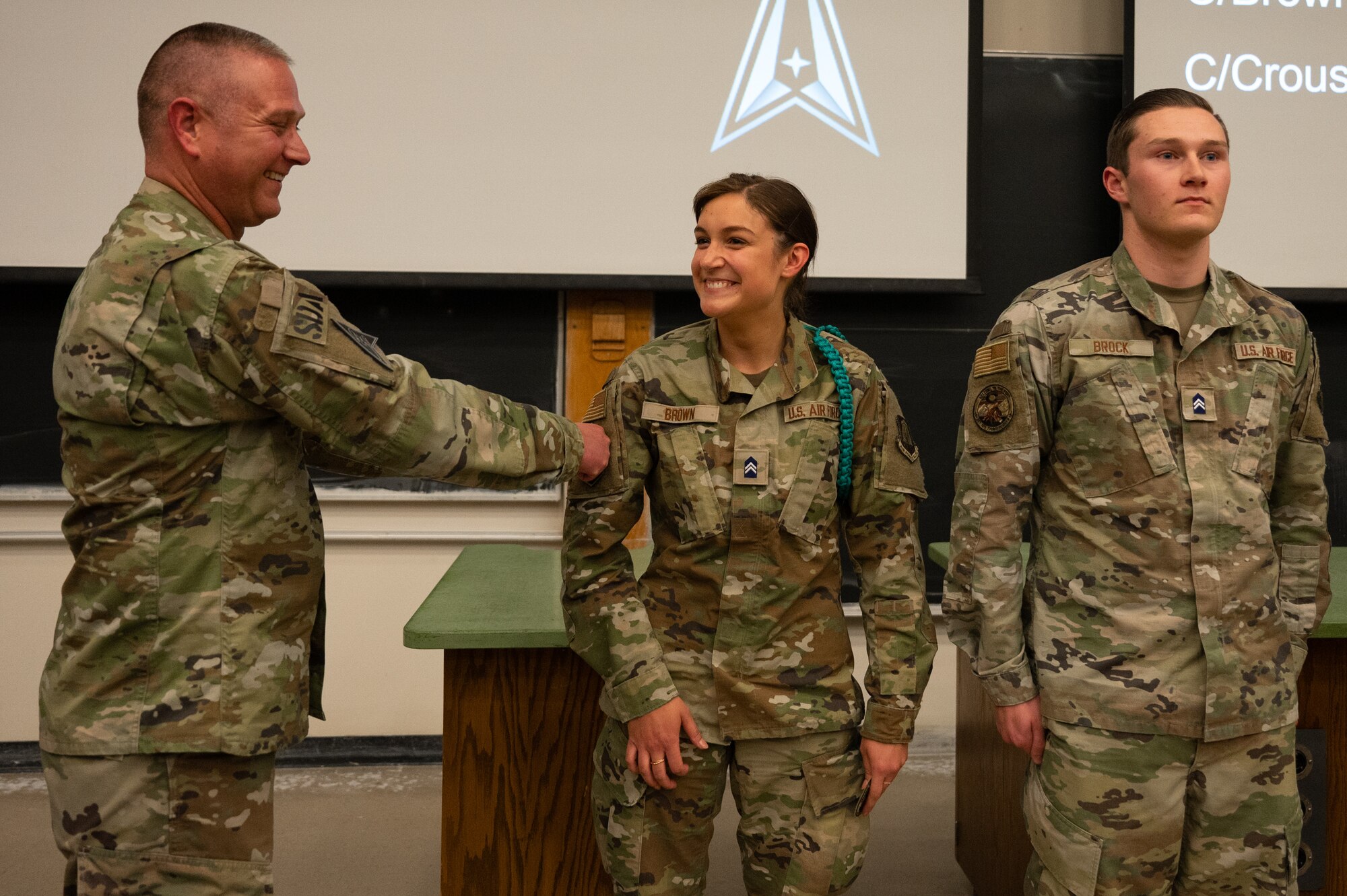 Man places patch on woman's uniform