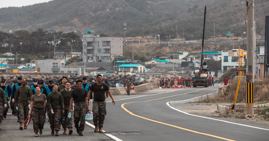 U.S. Marines and Republic of Korea Marines and Sailors walk together during a beach cleanup at Homigot Square, South Korea, on March 24, 2023. To help combat pollution, U.S. Marines, ROK Marines and Sailors, and local organizations across South Korea came together to clean the beach to promote friendship and work together towards a common goal. (U.S. Marine Corps photo by Lance Cpl. Jonathan Beauchamp)