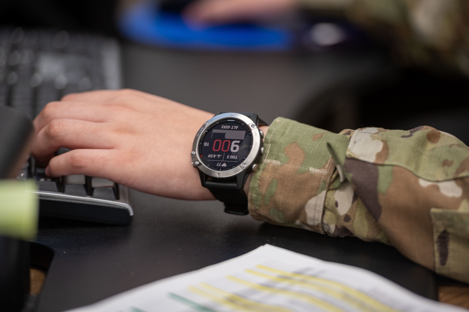 An airman's arm is pictured wearing a digital watch.