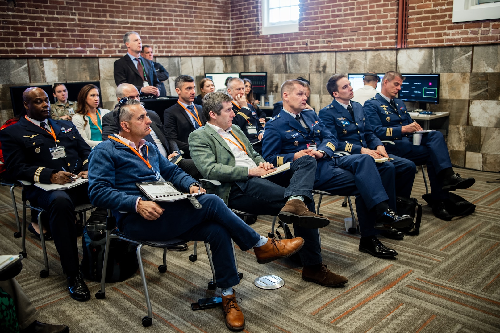 Group of people sitting in chairs listening to a presentation