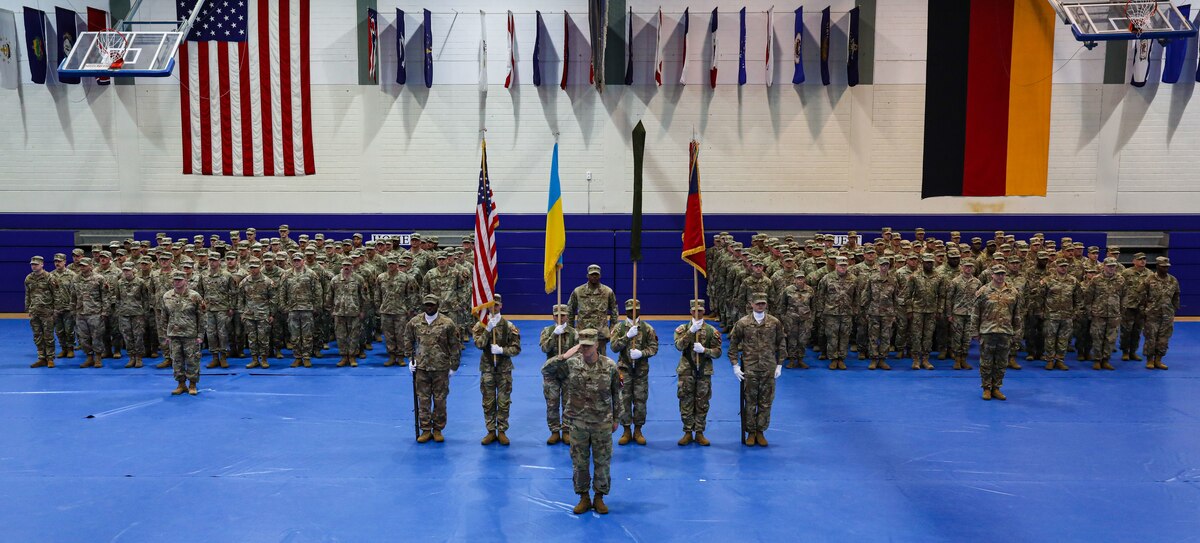 Service members stand in formation with U.S. and Ukraine flags.