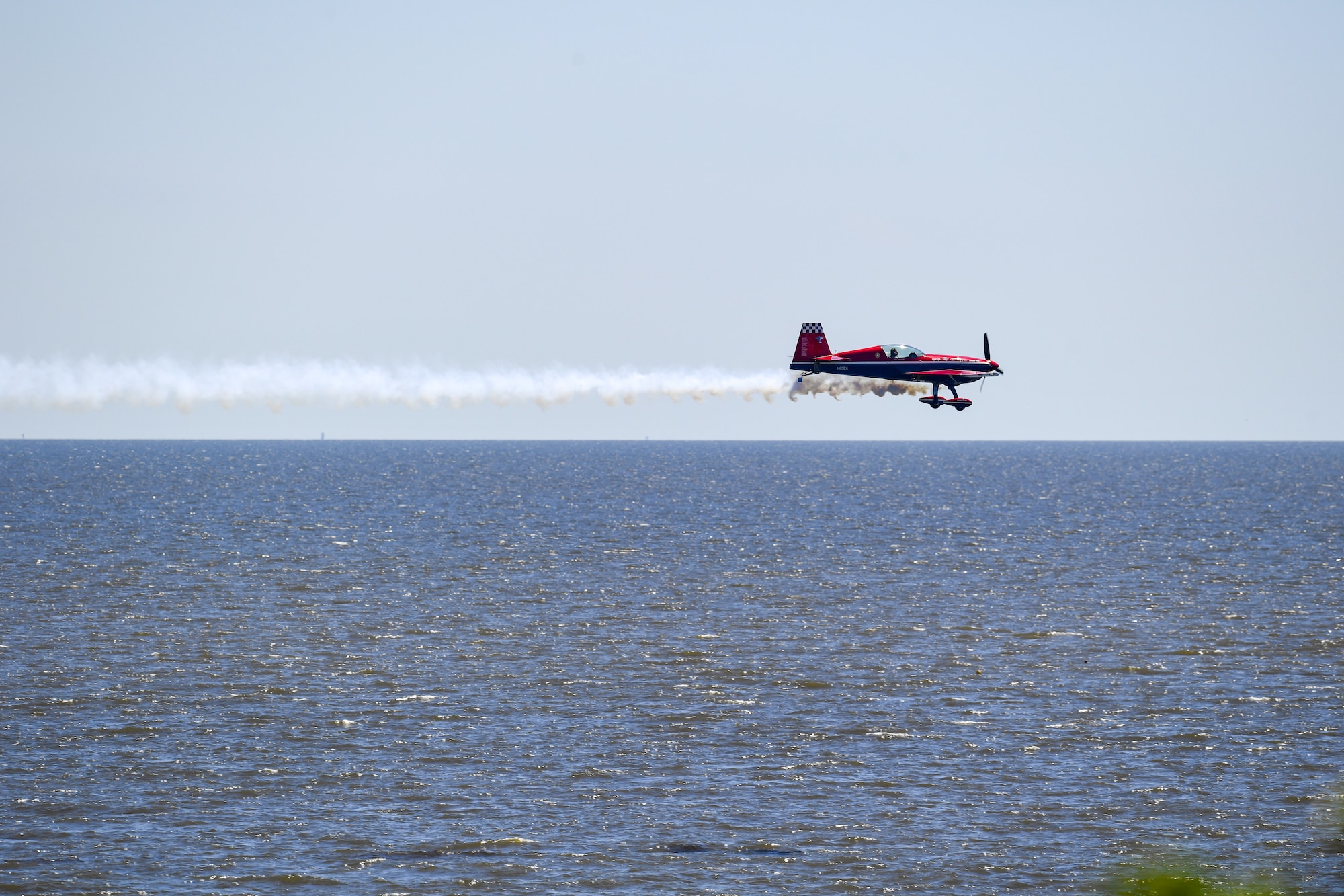 An EXTRA 300S flies over Biloxi Beach during a practice session for the 2023 Thunder Over the Sound Air and Space Show at Biloxi, Mississippi, April 28, 2023. Thunder Over the Sound is a unique event where a military installation and its surrounding city jointly host an air show in two locations; Biloxi Beach and Keesler's flightline. (U.S. Air Force photo by Kemberly Groue)