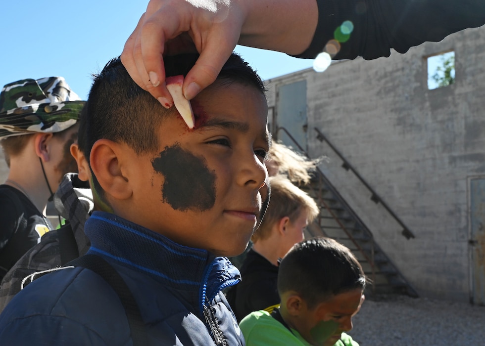 Gabriel Yanez, Op Kids participant, has makeup applied at the moulage station at Goodfellow Air Force Base, Texas, April 29, 2023. Moulage is the art of applying realistic, mock injuries for the purpose of training emergency response teams, medical, and military personnel. (U.S. Air Force photo by Airman 1st Class Madison Collier)