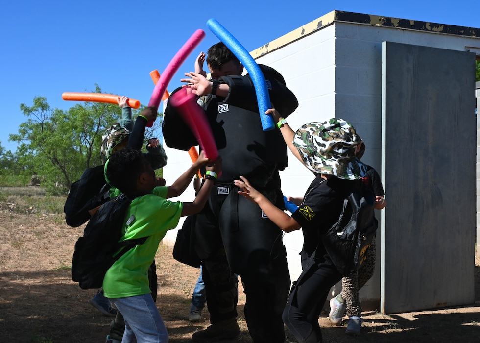 Children participating in Operation Kids practice self-defense tactics on a Marine volunteer at Goodfellow Air Force Base, Texas, April 29, 2023. Op Kids allows military children to see what their parents experience on deployment and allows children from civilian families in San Angelo to understand Goodfellow's role in national defense. (U.S. Air Force photo by Airman 1st Class Madison Collier)