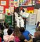 A Sailor from the USS Cole (DDG-67) reads to students at the Atlantic West Elementary School in Margate, Florida during Fleet Week Port Everglades. The US Navy has supported Fleet Week since 1990.
