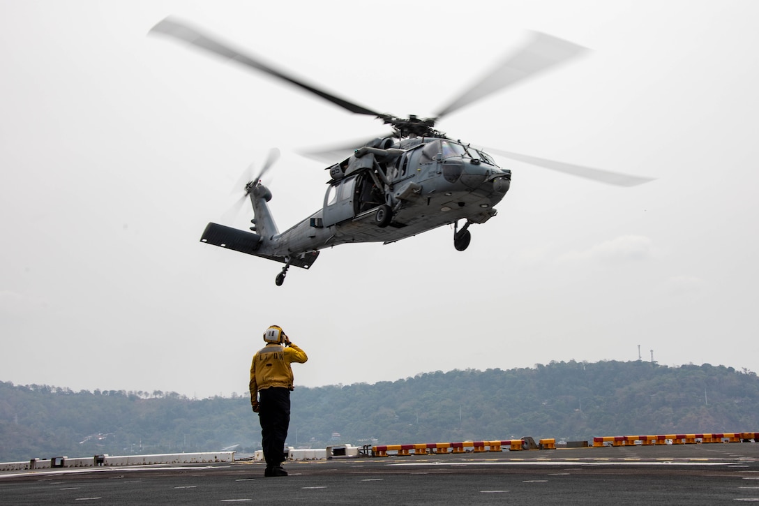 A U.S. Navy MH-60S Sea Hawk assigned to Helicopter Sea Combat Squadron 21 takes off from the flight deck of amphibious assault ship USS Makin Island (LHD 8), during Balikatan 23, April 12, 2023 in the Subic Bay Harbor. Balikatan is an annual exercise between the Armed Forces of the Philippines and U.S. military designed to strengthen bilateral interoperability, capabilities, trust, and cooperation built over decades of shared experiences. The Makin Island Amphibious Ready Group, comprised of Makin Island and amphibious transport docks USS Anchorage (LPD 23) and USS John P. Murtha (LPD 26), is operating in the U.S. 7th Fleet area of operations with the embarked 13th Marine Expeditionary Unit to enhance interoperability with Allies and partners and serve as a ready-response force to defend peace and maintain stability in the Indo-Pacific region. (U.S. Navy photo by Mass Communication Specialist 3rd Class Kendra Helmbrecht)