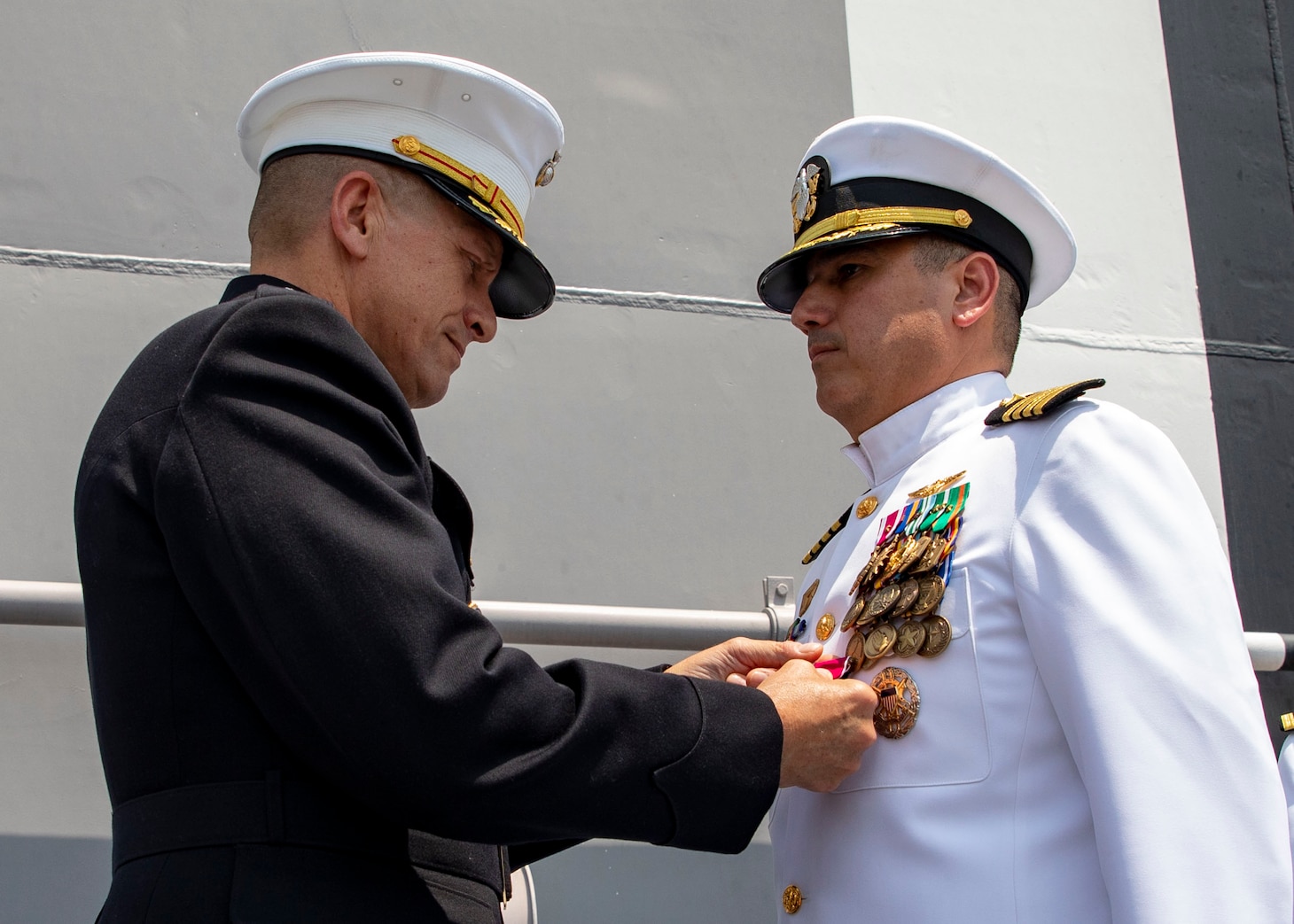 Brig. Gen. Fridrik Fridriksson, commanding general, 3d Marine Expeditionary Brigade, left, pins Capt. Tony Chavez, with an end of tour award during a change of command ceremony on the flight deck of amphibious assault ship USS Makin Island (LHD 8), April 28, 2023 in the the Philippines. The change of command ceremony is a time-honored naval tradition which formally proclaims the continuity and authority of command to the officers, men and women of the command. The Makin Island Amphibious Ready Group, comprised of Makin Island and amphibious transport dock USS Anchorage (LPD 23) and USS John P. Murtha (LPD 26), is operating in the U.S. 7th Fleet area of operations with the embarked 13th Marine Expeditionary Unit to enhance interoperability with Allies and partners and serve as a ready-response force to defend peace and maintain stability in the Indo-Pacific region.