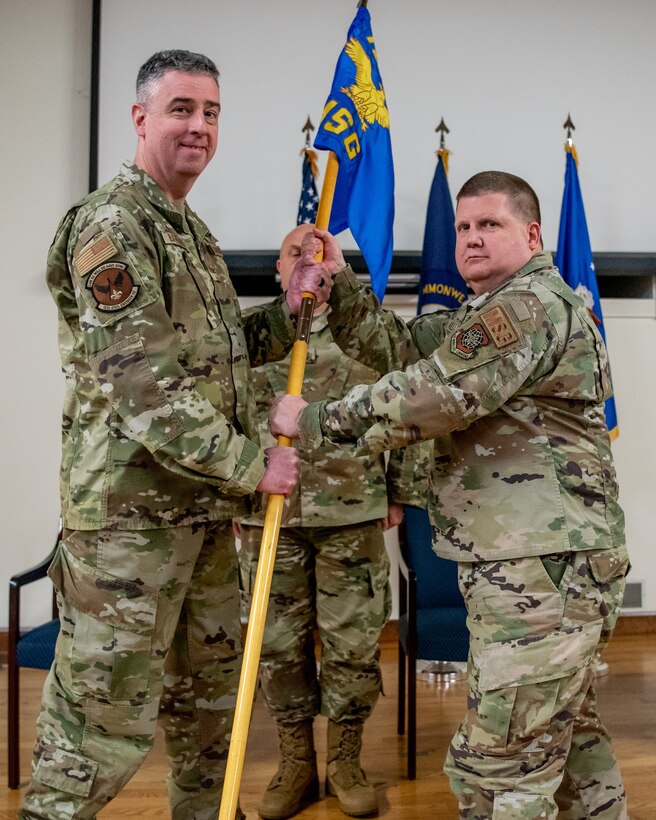 Col. Shawn Keller, right, incoming commander of the 123rd Mission Support Group, accepts the group's guidon from Col. Bruce Bancroft, left, 123rd Airlift Wing commander, during a change-of-command ceremony at the Kentucky Air National Guard Base in Louisville, Ky.,  Jan. 21, 2023. Keller is replacing Col. George Imorde, who is taking on the role of vice commander for the 123rd Airlift Wing. (U.S. Air National Guard photo by Tech. Sgt. Joshua Horton)