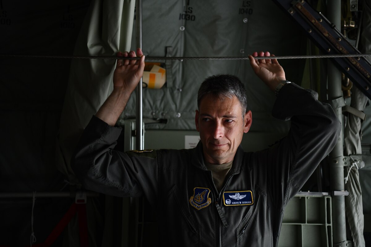A military man stands on a plane.