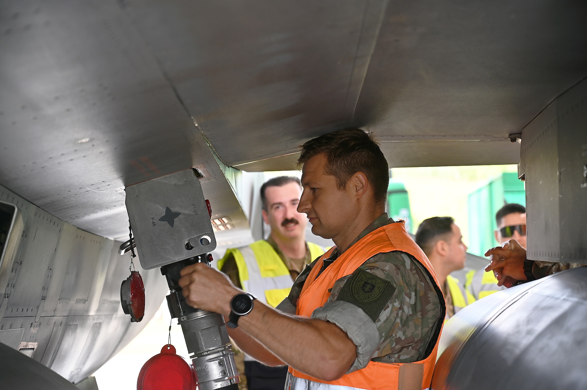 Military personnel works on aircraft