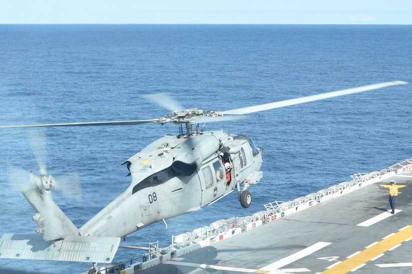 A helicopter lands on a ship.