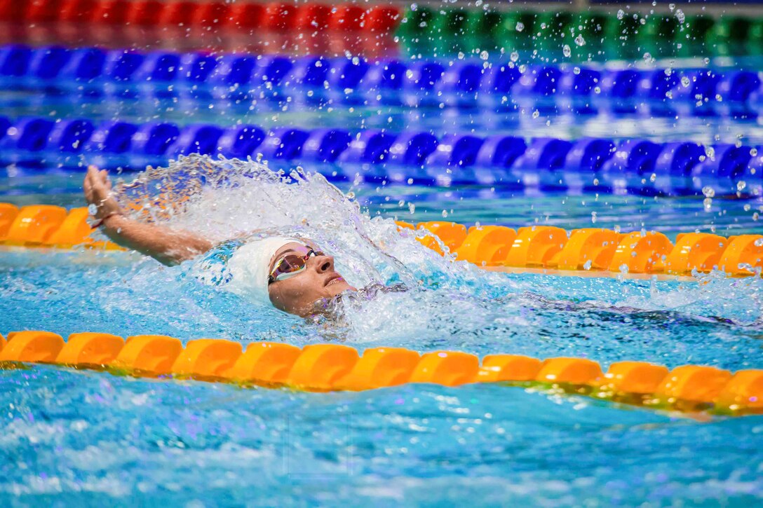 A soldier performs the backstroke in a pool.