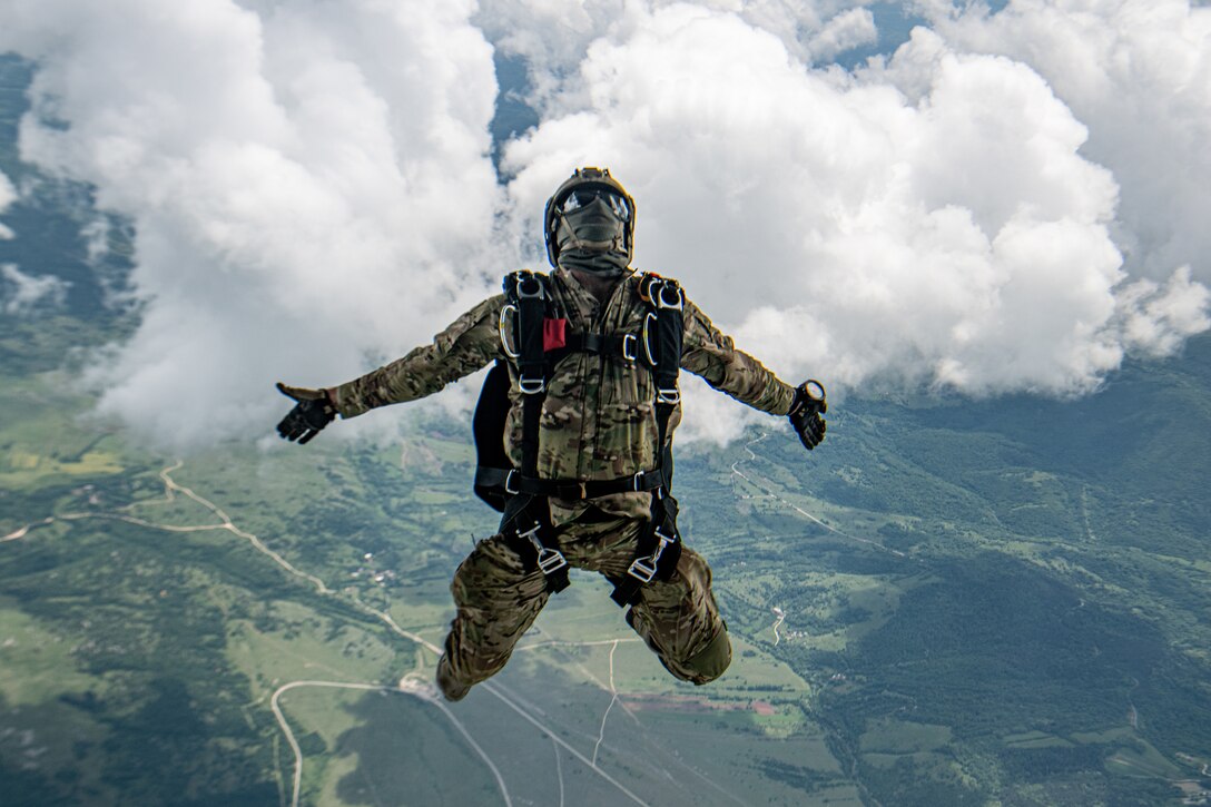 A sailor free falls from a military aircraft.