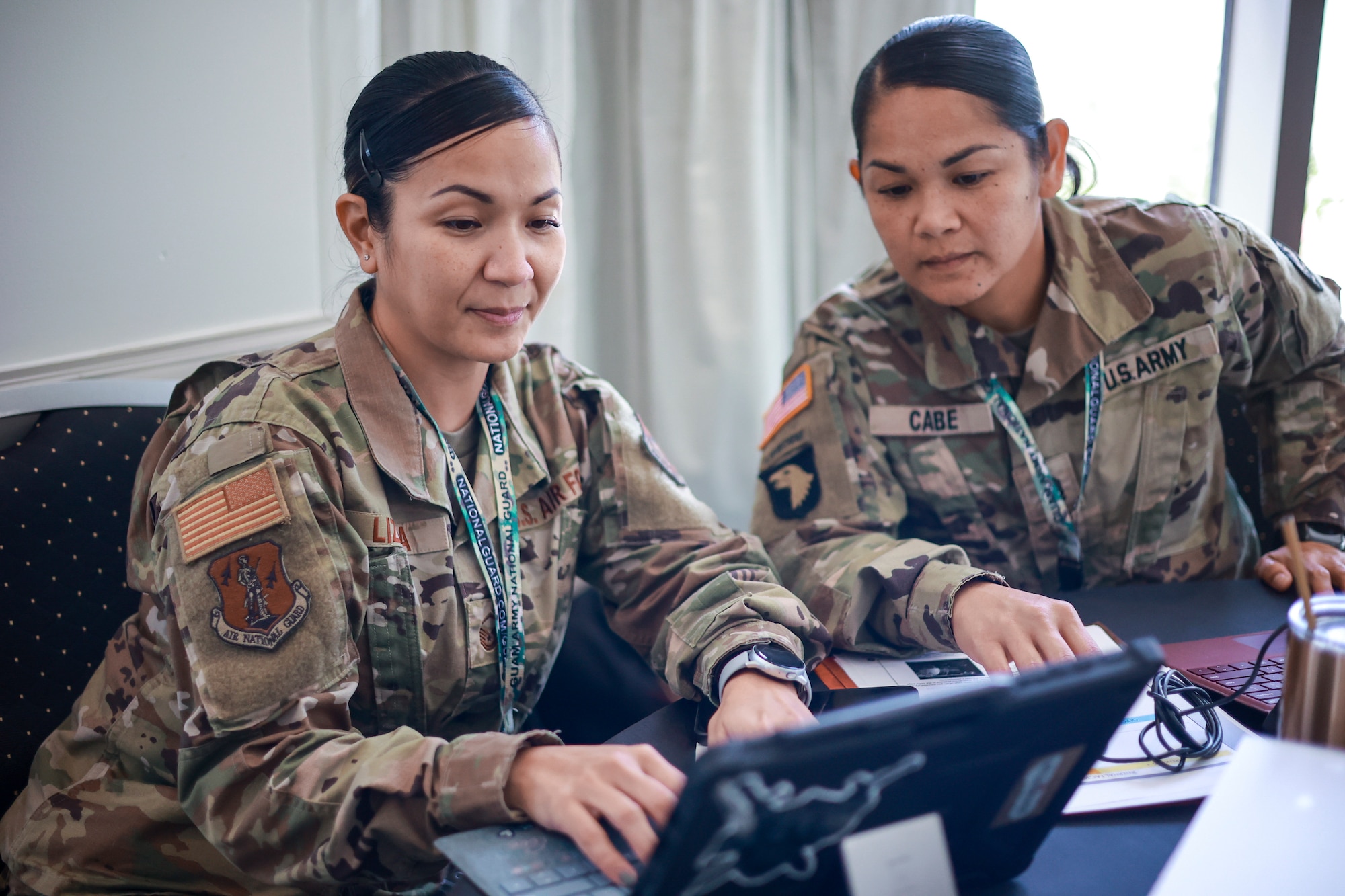 U.S. Air Force Master Sgt. Christine Lizama, left, and U.S. Army Sgt. 1st Class Jolina Cabe, both assigned to the Guam National Guard, attend a cybersecurity conference in Tumon, Guam, July 18, 2023. The conference was the first in a series of collaborations to develop, implement and sustain a unified cybersecurity plan for the U.S. territory in the Western Pacific.