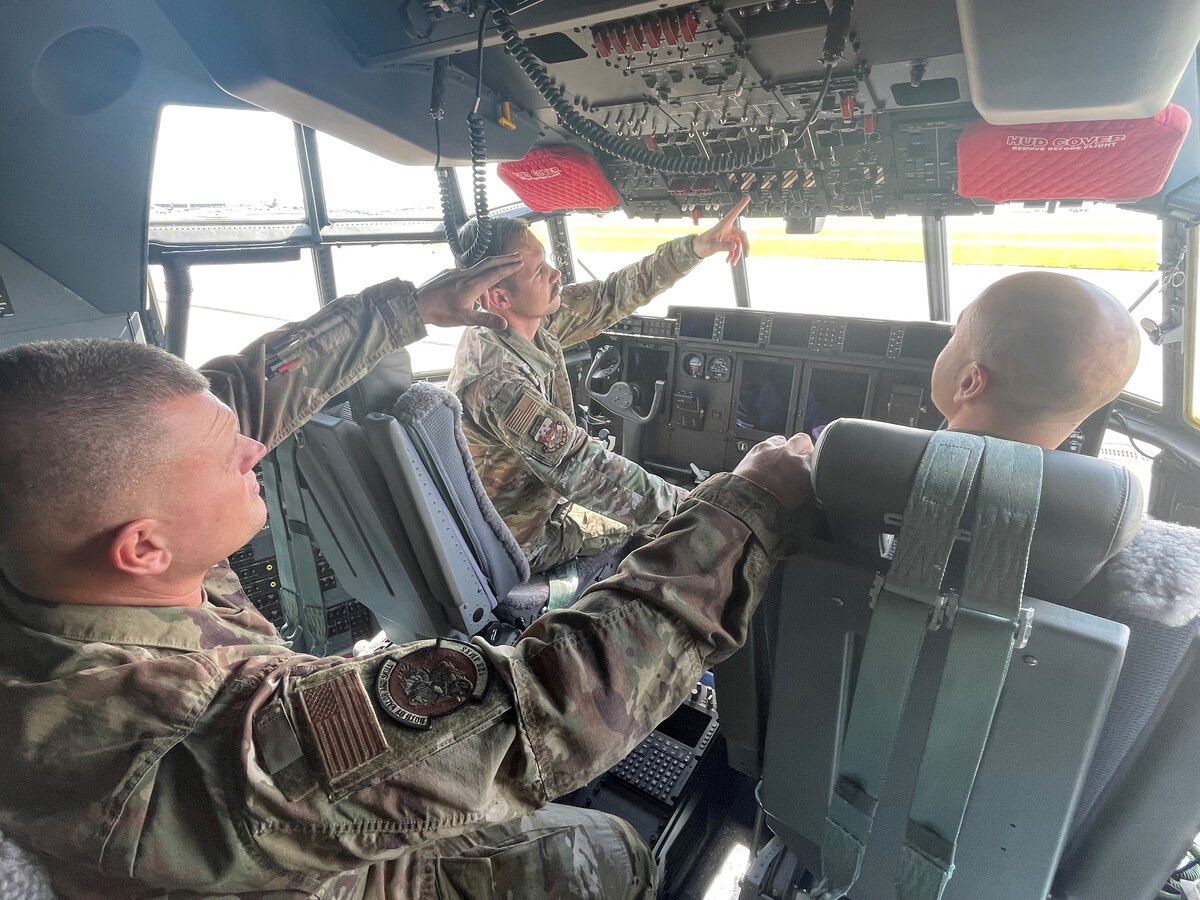 U.S. Air Force Staff Sgt. Tristan Grigsby, center, a C-130H Hercules maintainer assigned to the Advanced Airlift Tactics Training Center, Missouri Air National Guard, is trained on C-130J systems by Airmen with the 123rd Airlift Wing, Kentucky Air National Guard, at Louisville Air National Guard Base, Kentucky, May 3, 2023. During the two-week training, Grigsby and Senior Master Sgt. Ryan Breyfogle, aircraft maintenance superintendent with the AATTC, learned J-model fundamentals such as power on checklists, fueling operations, aircraft towing, operating radios, and general troubleshooting.