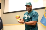 Defense Logistics Agency Troop Support Commander Army Col. Landis Maddox held his first workforce town hall on July 27, 2023, in Philadelphia posing with a mock DLA "secret sauce," and Philadelphia Eagles hat and jersey.