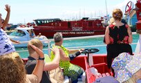 Illinois National Guard Gold Star Family members wave to a Chicago Fire Department boat during the Chicago Fire Boat Architectural Tour on Lake Michigan and the Chicago River after the CFD boat blew its air horn for the families.