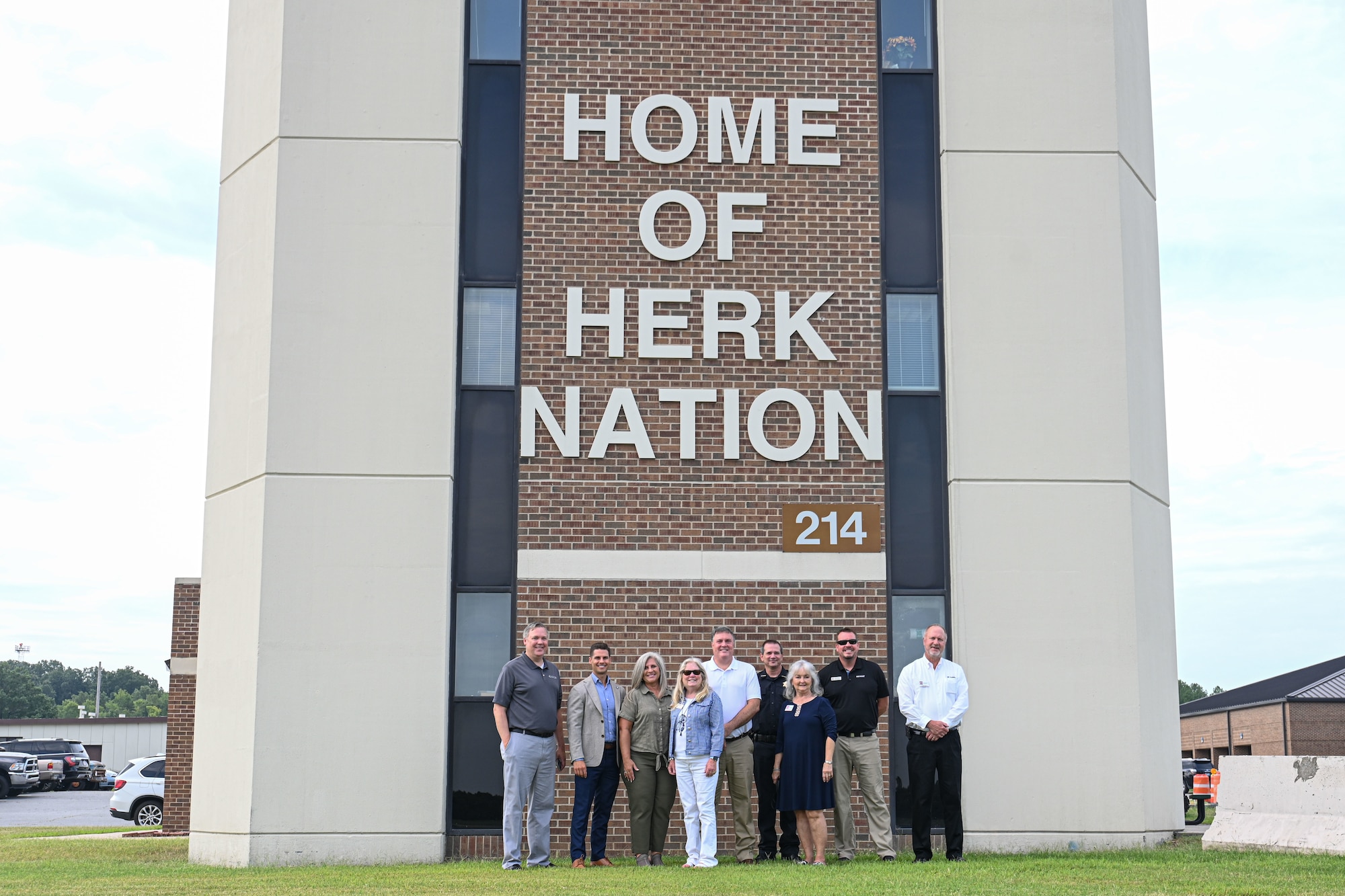 People pose in front of a building.