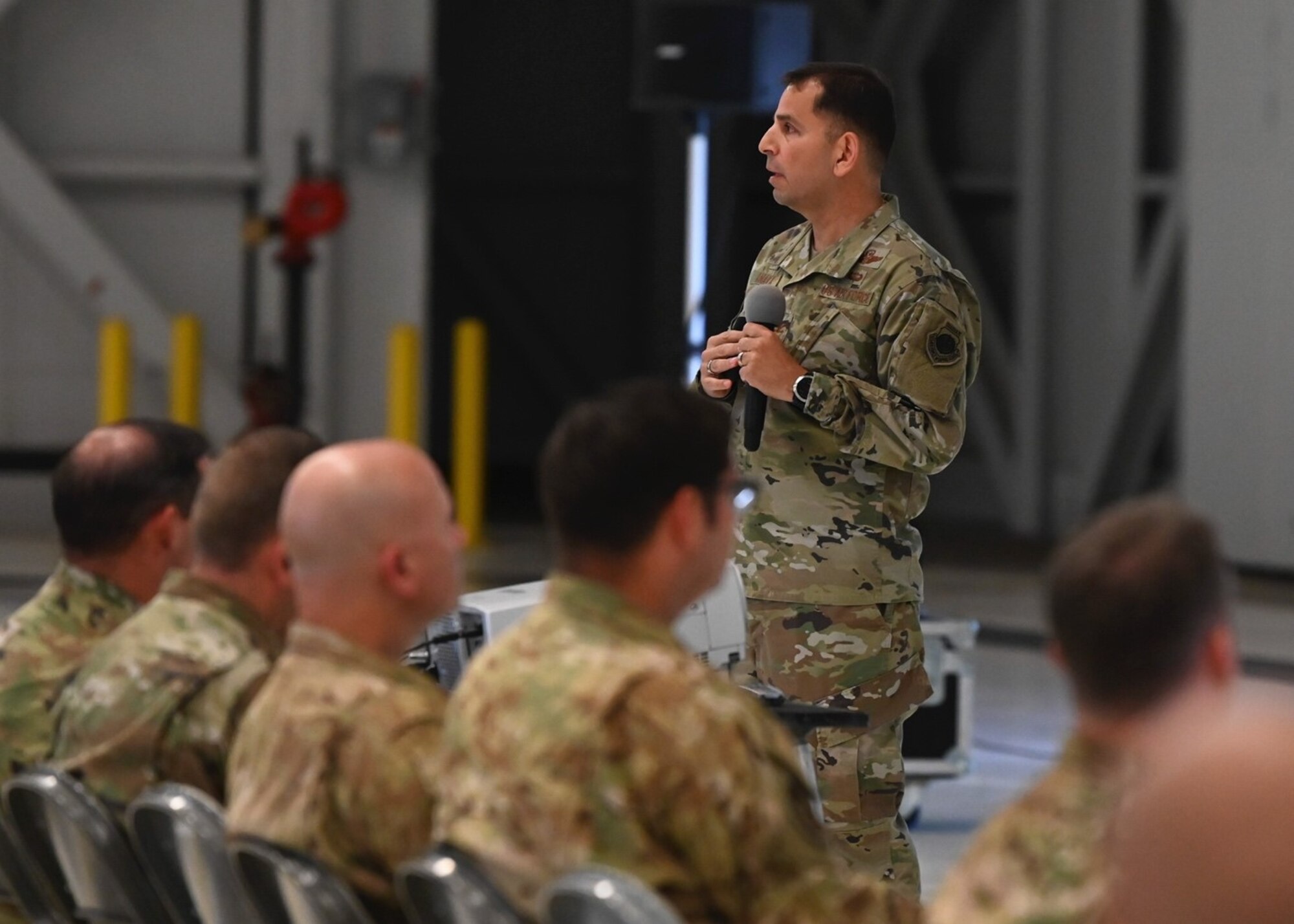 U.S. Air Force Col. Sergio Anaya, 62d Airlift Wing commander, addresses 62d AW Airmen during his first all-call as commander at Joint Base Lewis-McChord, Washington, July 31, 2023. During the all-call, Anaya emphasized his confidence in the mission’s execution, the training being developed for Airmen, and the Wing's Airmen themselves. (U.S. Air Force photo by Senior Airman Callie Norton)